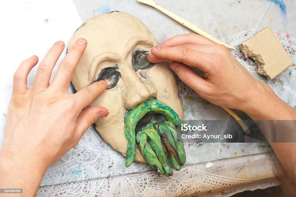 Hands sculpting plasticine form of face Man sculpting plasticine form of face with moustache Mask - Disguise Stock Photo