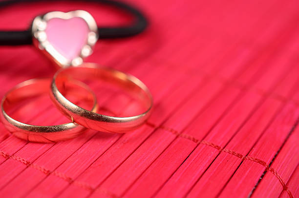 istock Orange gold-plated heart with two wedding rings 534107633