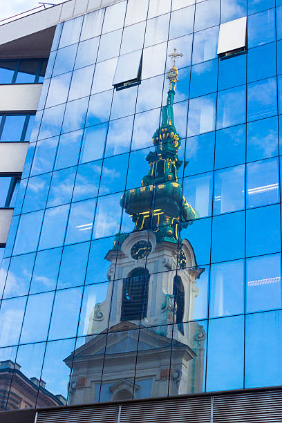 Reflection of old church in modern building windows, Stiftskirche, Mariahilferstrasse, Vienna
