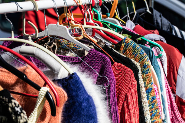 colorful women's sweaters for second life at flea market rack of fast fashion colorful women's sweaters on display for reselling,recycling,donation,reusing or welfare for second life sold at flea market, outdoors fashion bazaar stock pictures, royalty-free photos & images