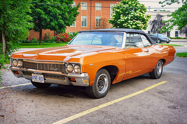 Hamilton, Canada - June 22, 2013: An orange colored 1970 Chevrolet Impala Convertible parked in a parking lot in Hamilton, Ontario.