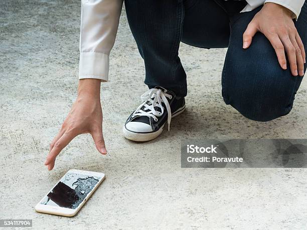 Person Picking Broken Smart Phone Of Ground Stock Photo - Download Image Now - Broken, Smart Phone, Mobile Phone