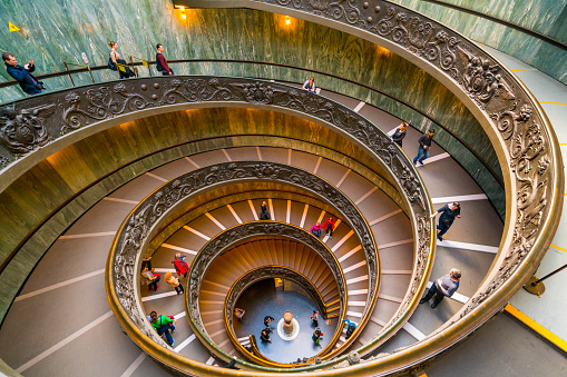 Vatican City State - March 2, 2016: People walking down the modern Bramante Staircase in a museum in Vatican.