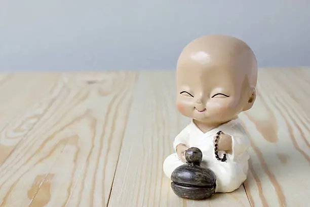 Little monk's praying, Statue neophyte on pine wood background
