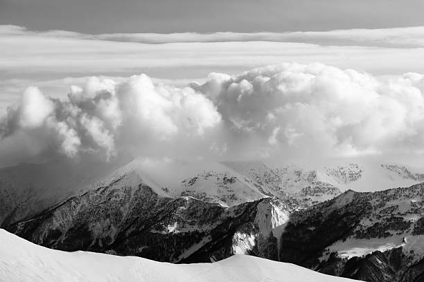 istock Black and white snowy mountains in clouds and off-piste slope 534130129