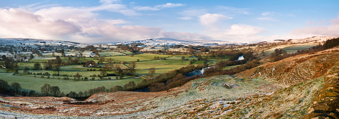 A wide angle view of the Upper Teesdale valley, County Durham. Image taken in winter looking up the Tees Valley towards Middleton-on-Tees with the River Tees meandering through the countryside and snow clouds looming over the distant peaks of the moors. sRGB embedded profile.