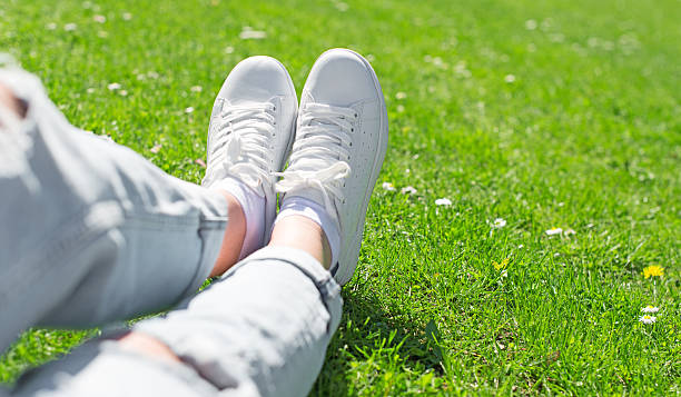 istock Legs in female sneakers on the grass. 534132598