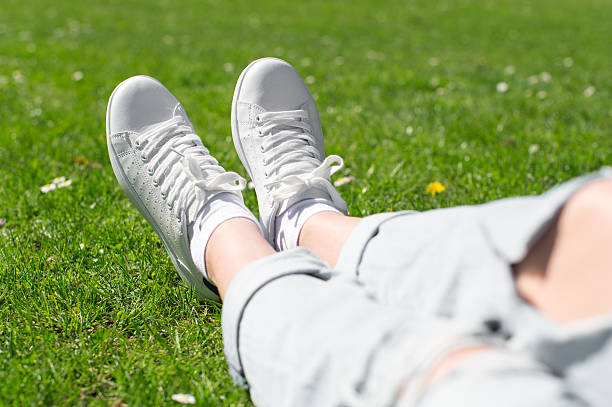 istock Legs in female sneakers on the grass. 534132658
