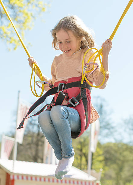 istock Little girl on bungee trampoline with cords. 534133050