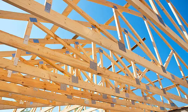Photo of Roofing Construction. Roof Trusses of New Home Building Construction.