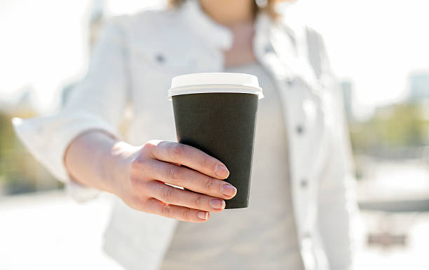 istock Woman's hands offering coffee cup outdoors. 534134092