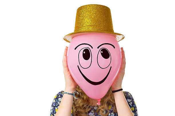 istock Girl holding balloon with smiling face and hat 534134711