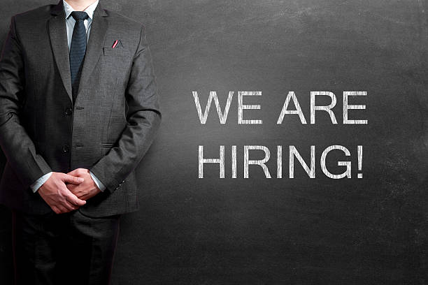 istock We are hiring text written on blackboard with businessman standing 534134749