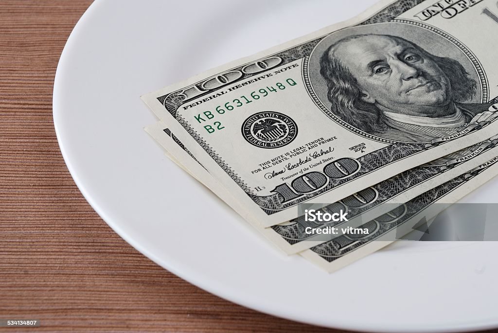 Dollar bank note money in the white plate Dollar bank note money in the white plate on the wooden table background  2015 Stock Photo