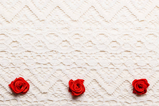 Valentines day wedding, invitation or greeting card. Red decorative satin rose flowers on white cloth lace background