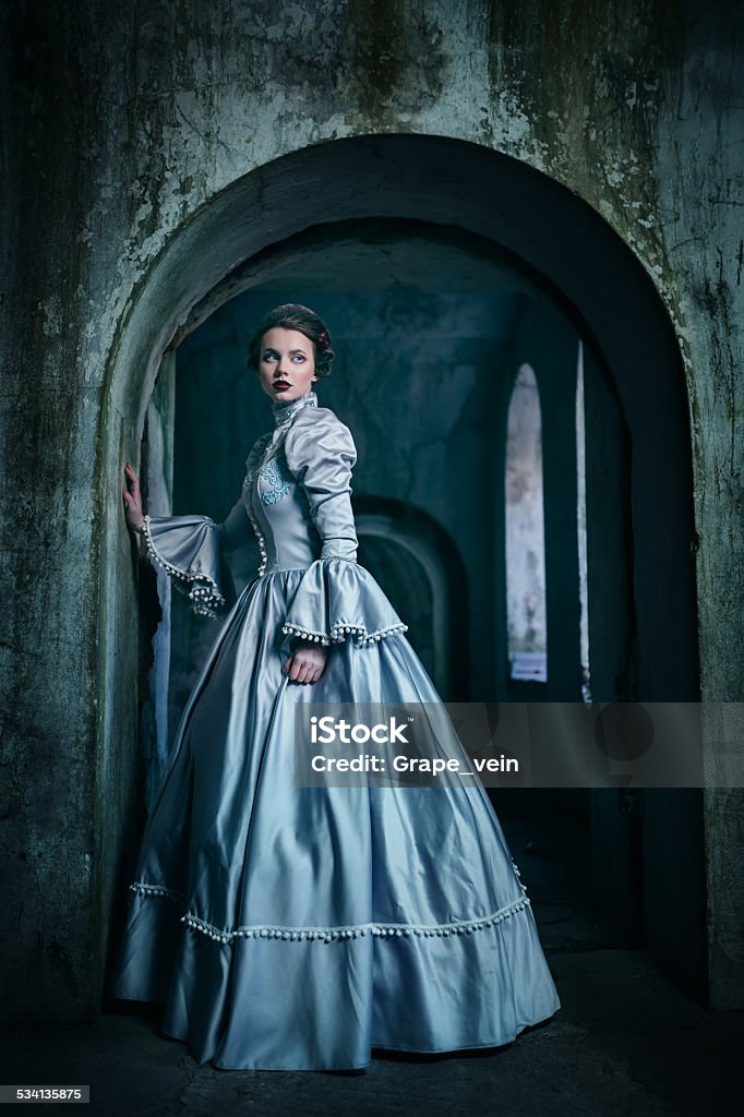 Woman in victorian dress Woman in victorian dress imprisoned in a dungeon Women Stock Photo