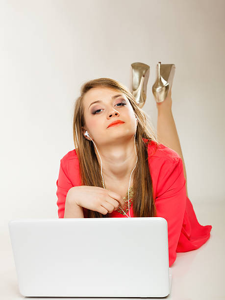Girl with earphones and computer listening to music Leisure free time, music, online and internet concept - happy teenage girl with earphones and laptop computer free girl download stock pictures, royalty-free photos & images