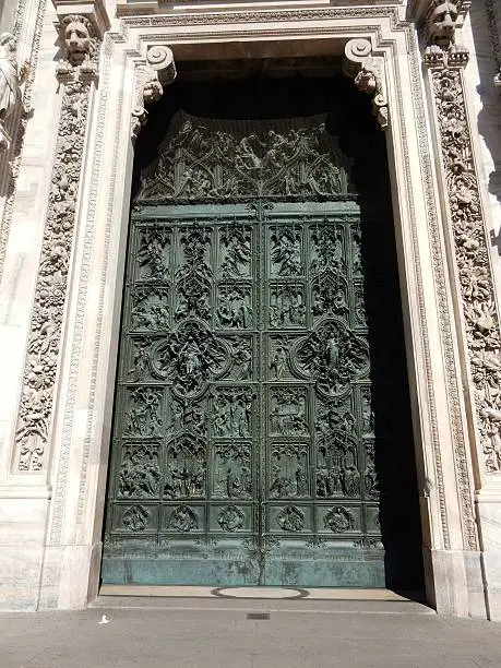 Milan, Lombardy, Italy - April 27, 2016: bronze door of the main entrance of the cathedral
