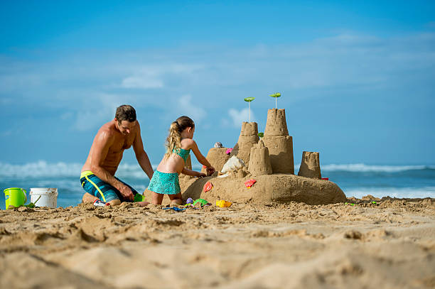 vater und tochter familie auf strand-gebäude sand-burg - sandburg struktur stock-fotos und bilder