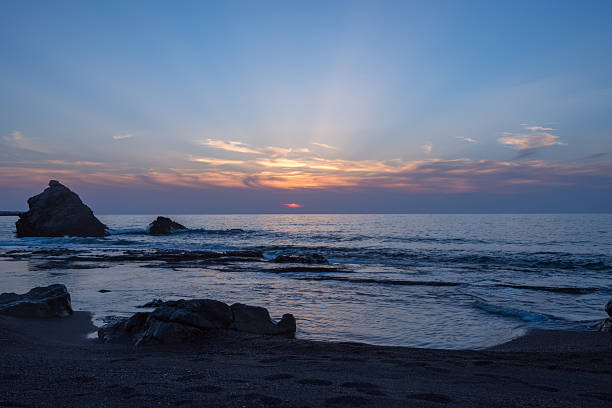 istock Waves splashing near lone rock, sunset 534139306