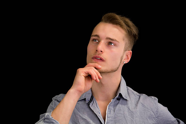istock Attractive young man thinking, looking up with hand on his 534139679