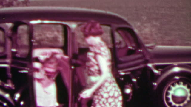 1937: Family exiting rear-hinged suicide door car visiting oceanside.