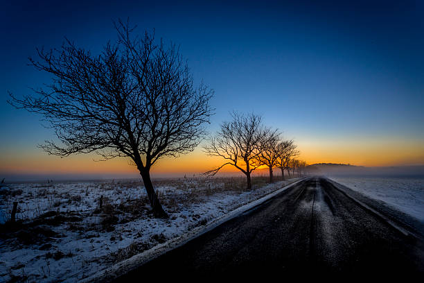 зимняя дорога на закате - winterroad стоковые фото и изображения