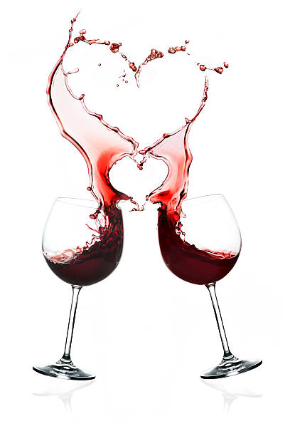 istock Two glasses of red wine with doubles hearts splashes 534156957
