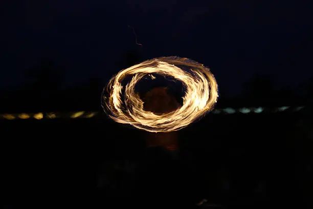 Long Exposure Image of Blurred Hawaiian Fire Dancer Creating Ring Shape with Fire Outdoors at Night