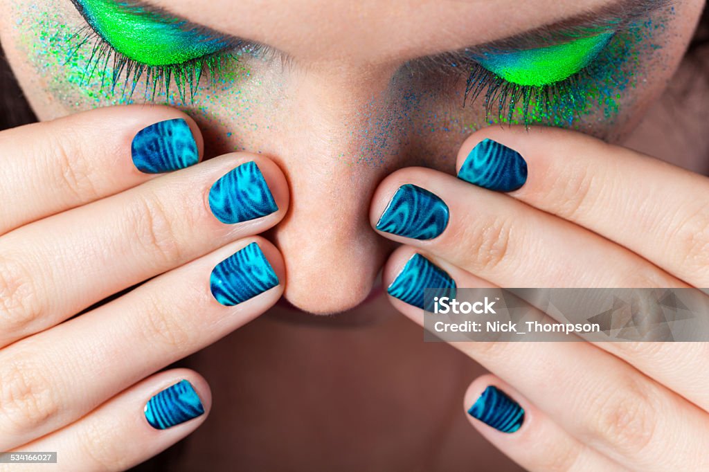 Woman's lips with beautiful multicolor Minx nails and make-up Woman's lips with beautiful multicolor holographic Minx nails and bright colorful make-up Holographic Stock Photo