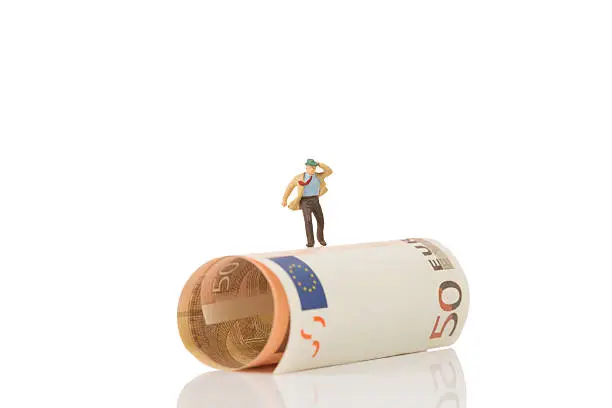 Photo of businessman figurine running on a euro banknote