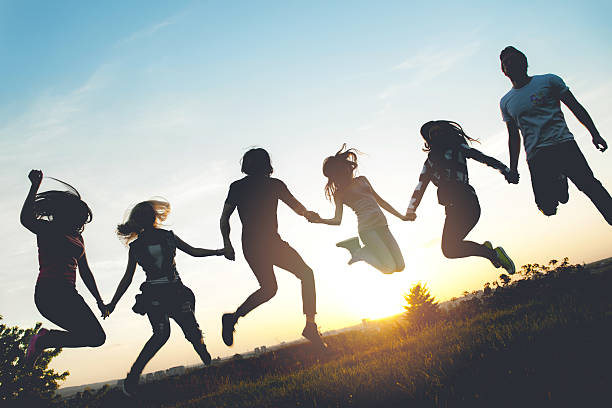 istock Group of people jumping outdoors; sunset 534189590