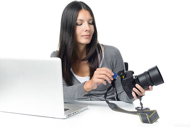 istock Female photographer inserting a card in her camera 534190495