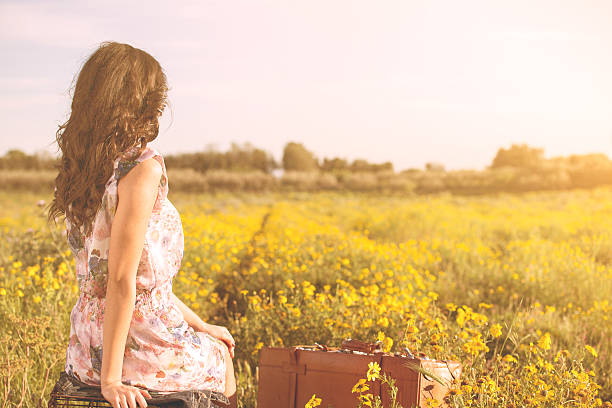 woman sitting in a field looking at the horizon