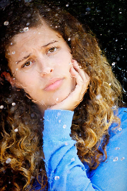 istock Will the rain ever stop? Despairing beauty looks through window 534199131