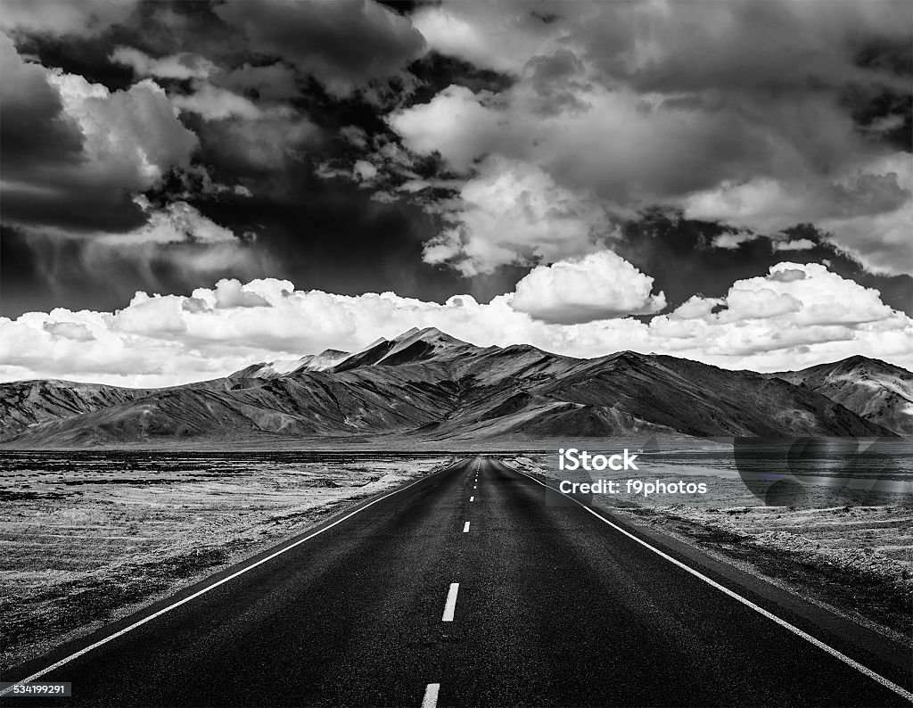 Road on plains in Himalayas with mountains Travel forward concept background - road on plains in Himalayas with mountains and dramatic clouds. Manali-Leh road, Ladakh, Jammu and Kashmir, India. Black and white version Black And White Stock Photo