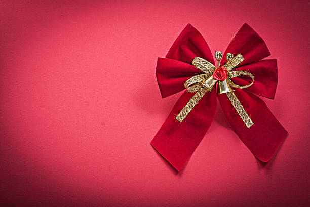 istock Christmas bow with bells on red background holidays concept 534199426