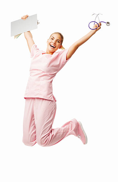 Full length portrait of successful female nurse jumping over white background. Vertical shot.