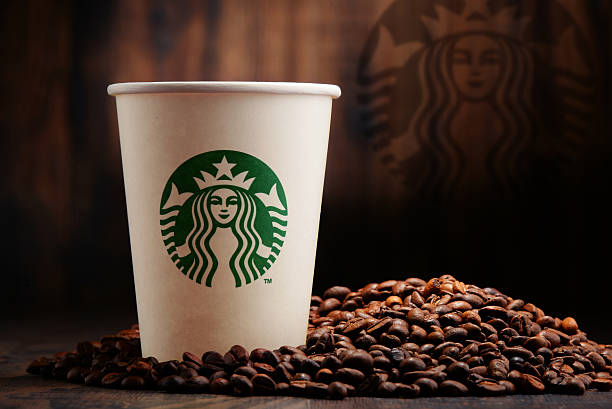 Komposition mit Tasse Starbucks-Kaffee und Bohnen – Foto