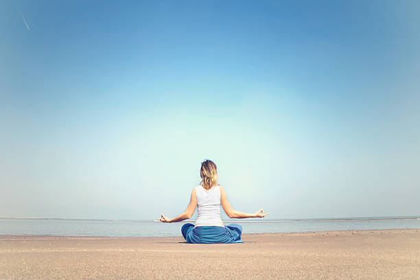 kobieta wykonywania relaksu i medytacji ćwiczenia na morze - spirituality yoga zen like meditating zdjęcia i obrazy z banku zdjęć