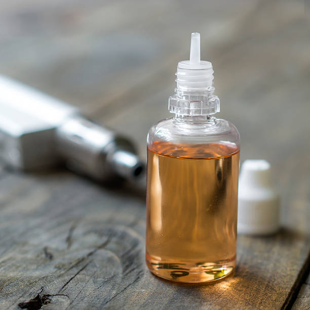 istock Electronic cigarette liquid flavour on wooden background 534207696