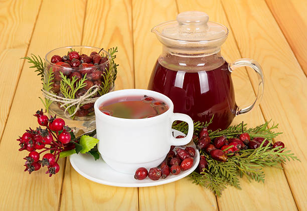 istock Jug,  cup of tea rosehip berries on  background light wood 534209960