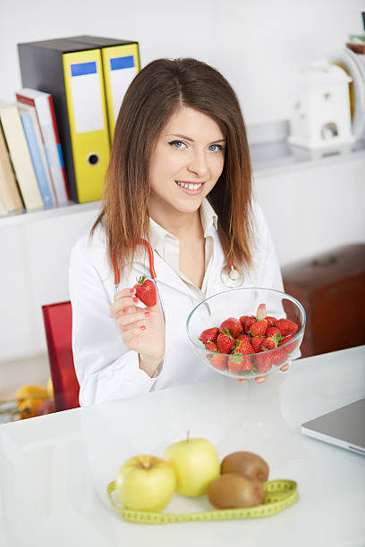 istock young nutritionist showing strawberries 534212592