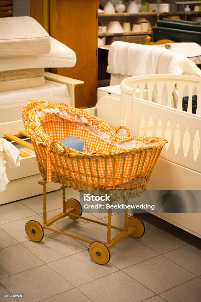 doll cradle in thrift store orange checkered doll cradle on wheels in thrift store Crib Stock Photo