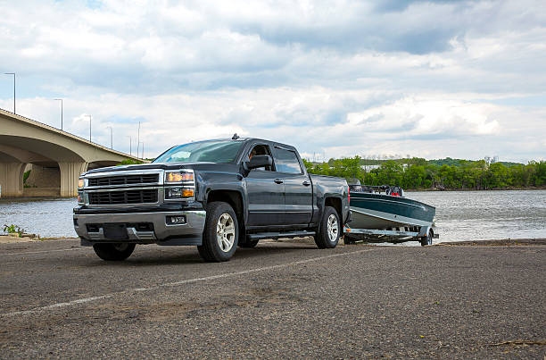 Truck with Boat in summer A truck backing up to a boat launch.  towing photos stock pictures, royalty-free photos & images