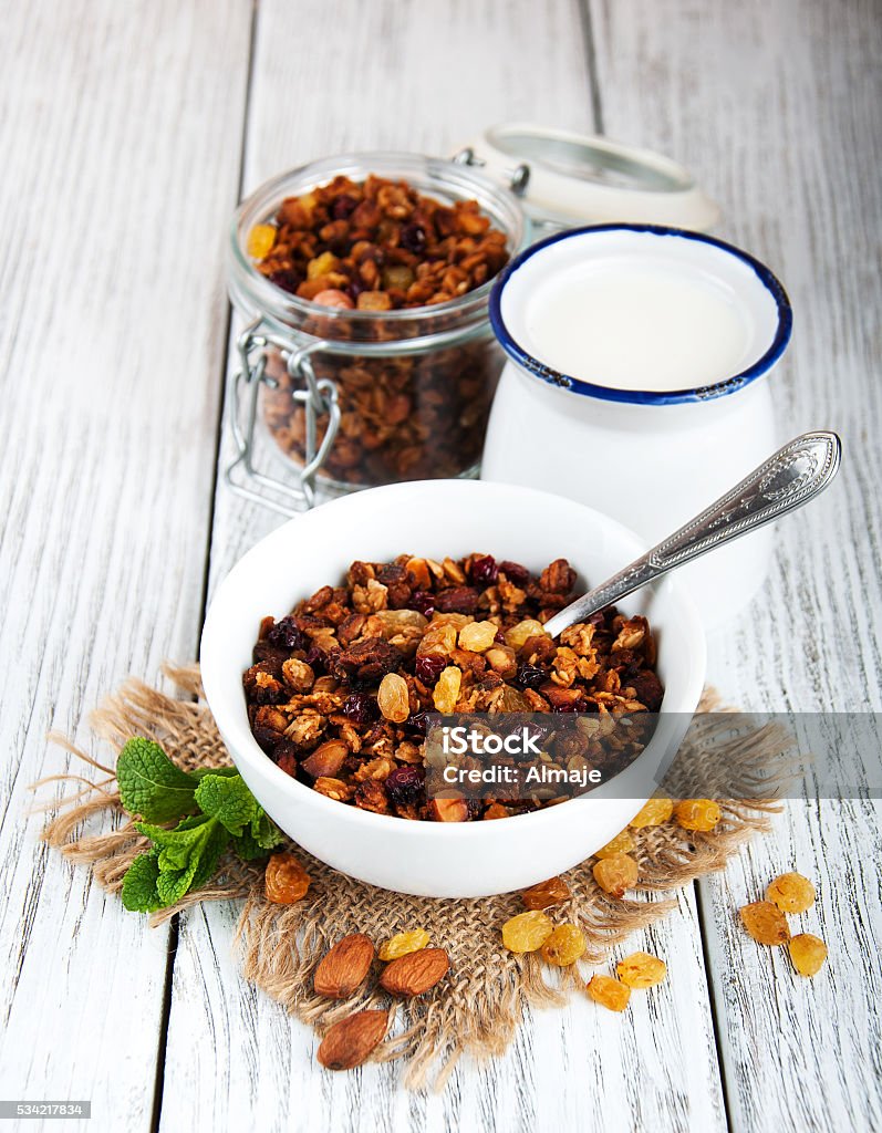 Homemade granola Homemade granola with nuts, milk and honey on a wooden table Almond Stock Photo