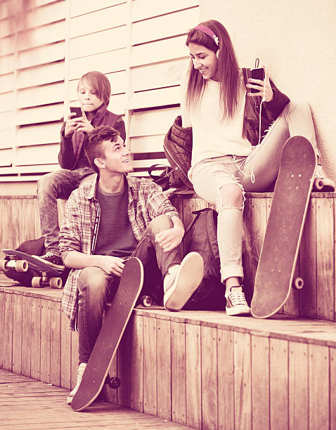 adolescentes felices jugando en smarthphones y escuchar música - video game friendship teenager togetherness fotografías e imágenes de stock