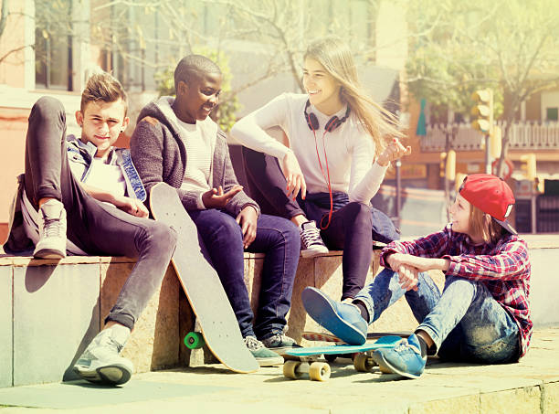 istock girl and three boys hanging out outdoors and discussing somethin 534218232