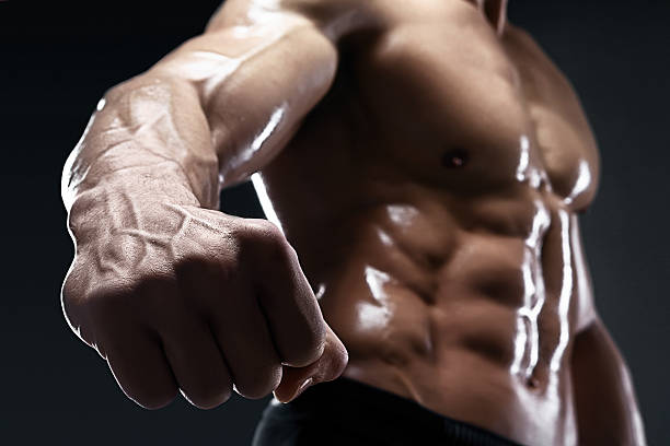 istock Handsome muscular bodybuilder shows his fist and vein. 534220164