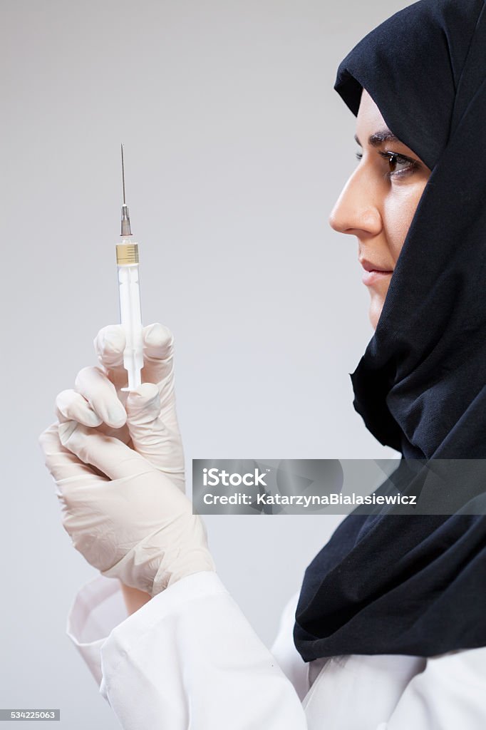 Muslim doctor before injection Vertical view of muslim doctor before injection Islam Stock Photo